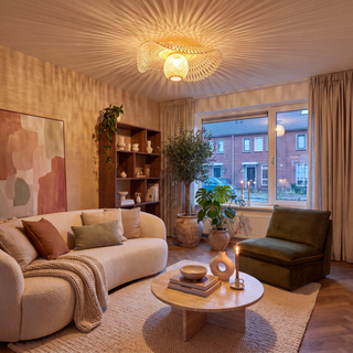 gestyltes wohnzimmer mit rattan deckenleuchte und bouclé-sofa